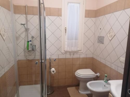 Moderno bagno nella casa vacanze La Maison Du Port con doccia, toilette, bidet, lavabo e piastrelle beige
