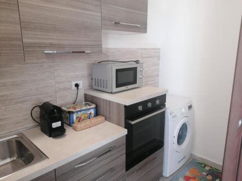 Modern kitchenette at La Maison Du Port, Licata with microwave, stove, washing machine and compact appliances