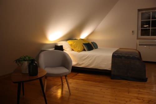 Chambre cosy sous les toits à Théière & Couverts à Cernay avec lit, coussin jaune, fauteuil gris et parquet