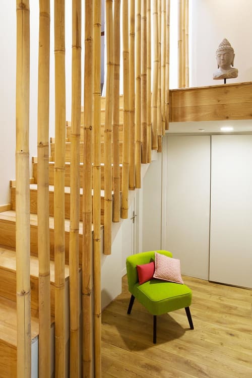 Modern B&B interior at AJOUCADOU, Lourmarin with bamboo partition, green accent chair, and Buddha sculpture