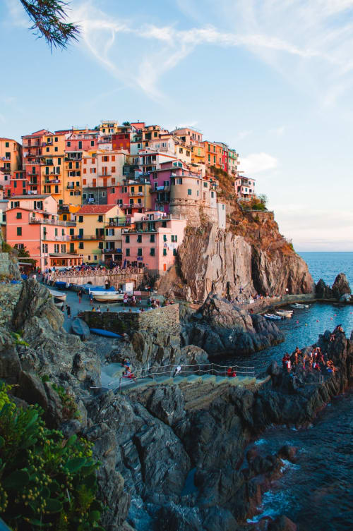 Suggestivo villaggio arroccato con edifici color pastello affacciato sul blu intenso del Mar Mediterraneo e la rocciosa costa