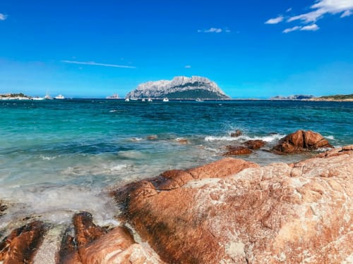 L'Isola della Tavolara vista dalla costa rocciosa di Alghero con le acque turchesi del Mediterraneo