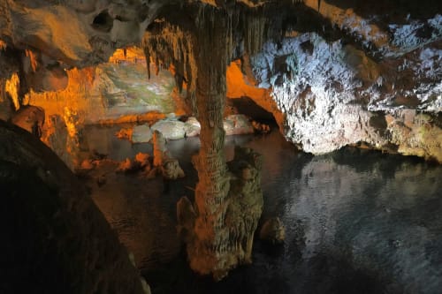 Stalattiti illuminate e lago sotterraneo nella grotta di Alghero vicino all'hotel Catalogna10 Rooms e Loft