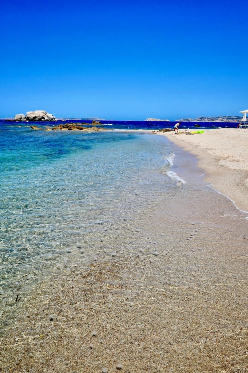 Spiaggia turchese cristallina ad Alghero con sabbia, rocce e nuotatore, ideale per gli ospiti del Catalogna10