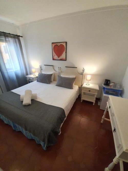 Economy double bedroom at Ocean View Lagos hostel with twin beds, white bedding, garden view window, and shared bathroom