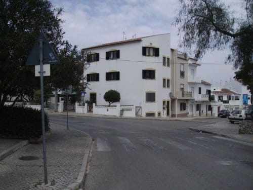 Fachada do albergue Sunny House em Lagos, Portugal - edifício branco com portadas pretas em rua tranquila
