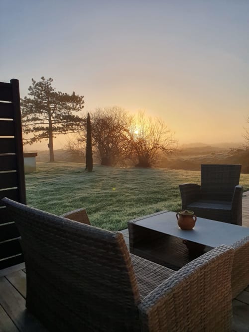 Terrasse givrée de la villa Gîtes De La Grande Borderie à Saint-Gervais avec mobilier en rotin dominant le brouillard