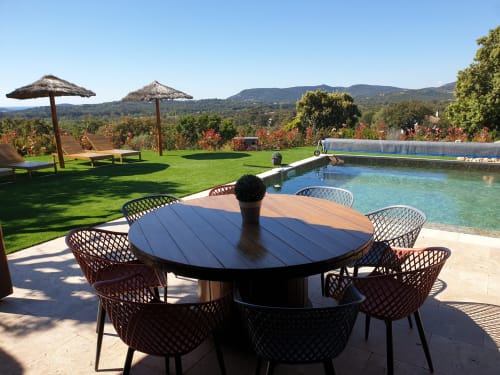 Terrasse de piscine luxueuse avec table ronde, transats et vue sur les vignobles à Porto-Vecchio