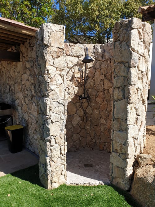Douche extérieure en pierre naturelle à la villa Villas-Majos à Porto-Vecchio, Corse, avec pommeau de douche effet pluie