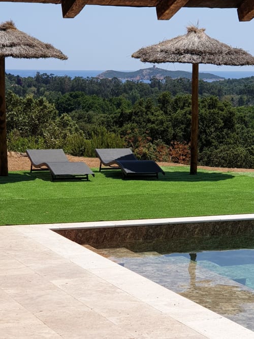 Villa de luxe à Porto-Vecchio avec vue mer, transats, piscine, parasols de chaume et paysage côtier