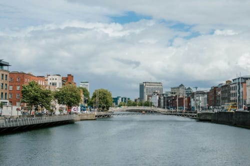 Dublin Exchange Suites overlooks the River Liffey with historic brick buildings and footbridge in the background