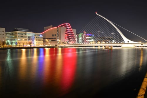 Dublin's Samuel Beckett Bridge and illuminated waterfront at night, iconic cityscape near Exchange Suites