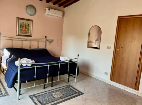 Camera da letto spaziosa dell'Apartment Tirreno a Tirrenia con letto in metallo, aria condizionata e comfort moderni