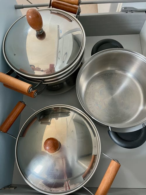 Set di pentole in acciaio inox con coperchi in vetro nella cucina dell'Apartment Tirreno, Tirrenia