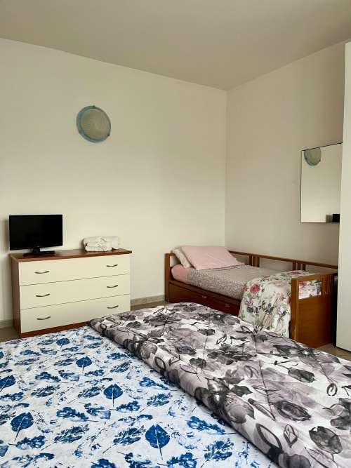 Camera da letto standard in Apartment Tirreno a Tirrenia con due letti, TV, comò e specchio