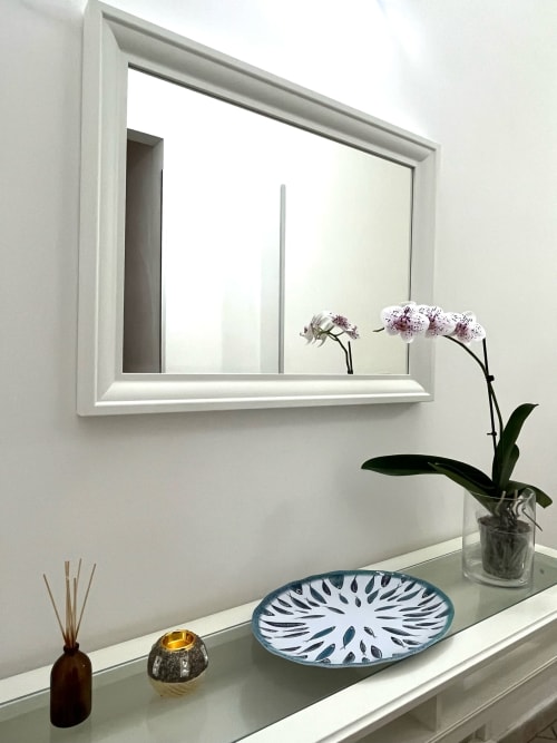 Elegante mobile da bagno presso l'Apartment Tirreno con specchio bianco, orchidea e accessori decorativi a Tirrenia