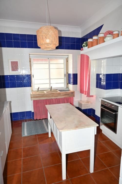 Cozinha moderna na Villa Sor em Ponte de Sor com azulejos azuis e brancos, mesa de jantar e eletrodomésticos