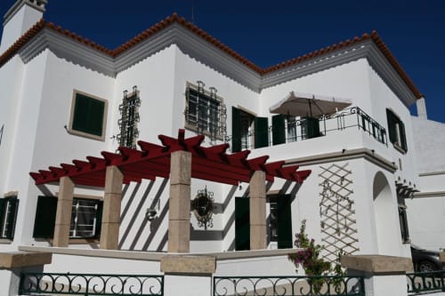 Villa Sor em Ponte de Sor com fachada branca, telhado de barro, pérgola vermelha, postigos verdes e pilares de pedra