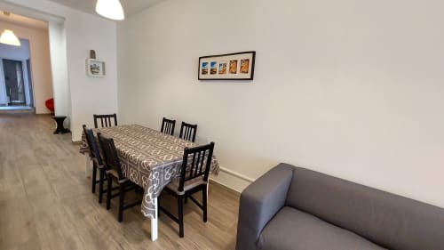 Dining area with black chairs and patterned tablecloth in Barcelona apartment Clot Patio 1, grey sofa visible in foreground
