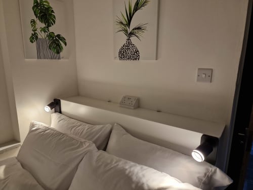 Modern bedroom at The Little Annex in Horsham with bed, wall art, reading lights, and bedside outlets