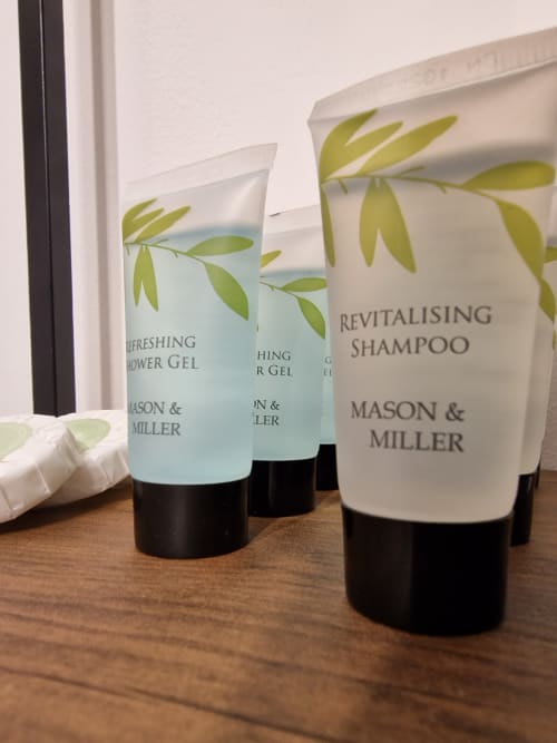 Mason & Miller toiletries displayed on wooden surface at The Little Annex apartment in Horsham, featuring revitalising