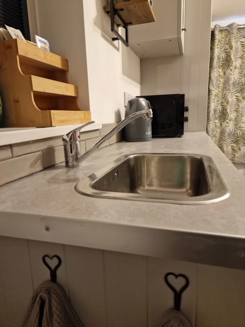 Modern kitchenette with stainless steel sink and chrome faucet at The Little Annex apartment in Horsham