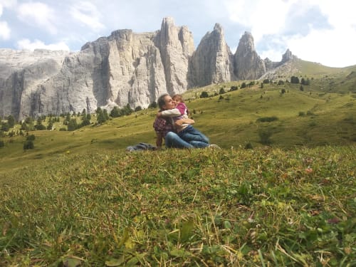 Eltern und Kind genießen die Aussicht auf alpine Wiesen bei der Residenza Rodolon bei Mazzin in den Dolomiten