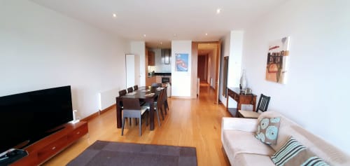 Dublin Exchange Suites 2-bedroom apartment with dining table, living area, hardwood floors, and kitchen visible.