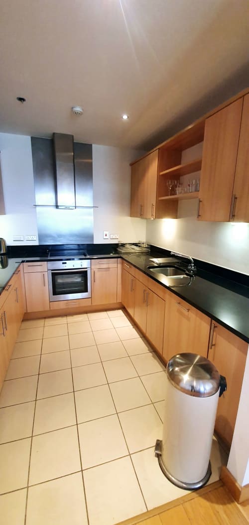 Modern kitchen with wooden cabinets, black countertops, stainless steel appliances at Dublin Exchange Suites