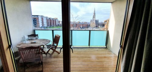 Dublin apartment balcony with dining table, chairs, and views of the city skyline and river