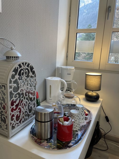 Station thé et café dans la chambre de La Montagnette B&B avec vue montagne par la fenêtre, Moutiers