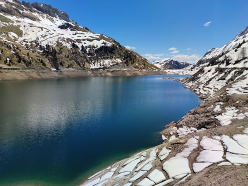 Alpiner See umgeben von schneebedeckten Bergen in der Nähe des Residence Rodolon, Mazzin, Italien