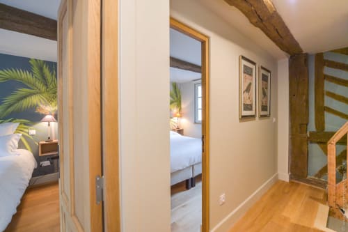 Hallway entrance to bedroom in Pierre and Valérie cottage, Honfleur, with wooden beams and mirrored doors