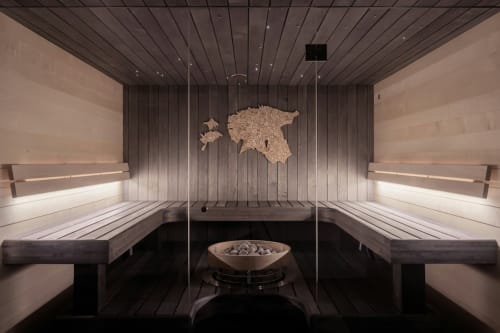Moderne Sauna im Residence Rodolon in Mazzin mit Holzbänken, Steinwandkunst und Heizelementen