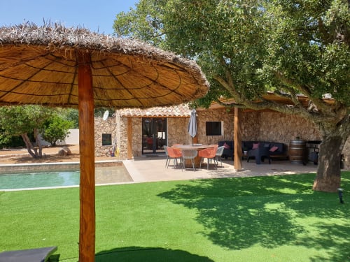 Patio de la villa Villas-Majos avec parasol en chaume, piscine, bâtisse en pierre et jardin luxuriant à Porto-Vecchio