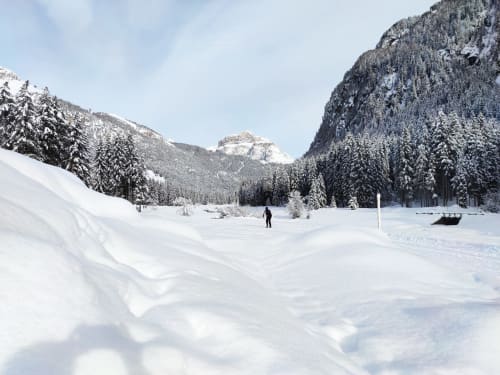 Schneebedeckter Bergsee umgeben von Nadelwäldern und Bergen in der Nähe der Residence Rodolon in Mazzin