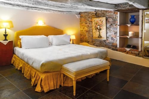 Letto giallo brillante con biancheria bianca presso l'Appartamento Le Viole, Dimora i Manichei a Monforte d'Alba