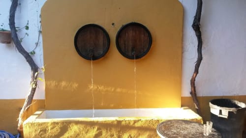 Yellow bathroom sink with two circular mirrors and vine branches at Bungalow Buda Beach, Chipiona
