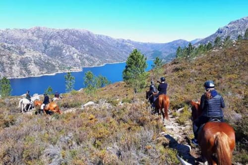 Grupo a cavalo admirando lago azul nas montanhas perto da Casa da Luz Gerês, Portugal