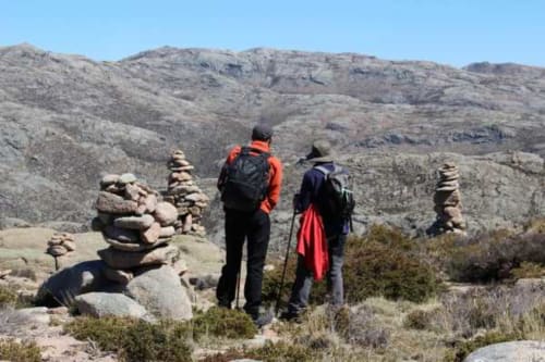 Dois caminhantes com mochilas exploram o terreno rochoso das montanhas perto da Casa da Luz Gerês em Vieira do Minho