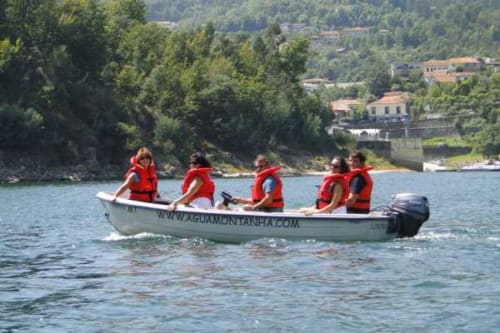 Cinco pessoas com coletes de salvação vermelhos em um barco no rio Gerês, Vieira do Minho