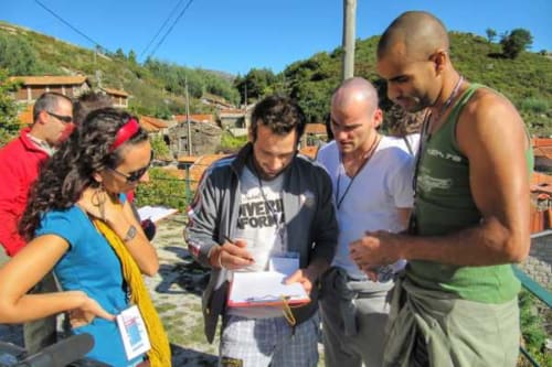 Grupo revisando documentos na Casa da Luz Gerês em Vieira do Minho, Portugal durante encontro de equipe ao ar livre