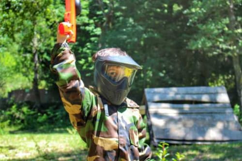 Jogador de paintball em uniforme de camuflagem mira marcadora na área de atividades ao ar livre Casa da Luz Gerês em Vieira do Minho