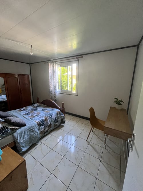 Chambre lumineuse à l'Au pied des Sources à Cilaos avec lit, bureau et carrelage