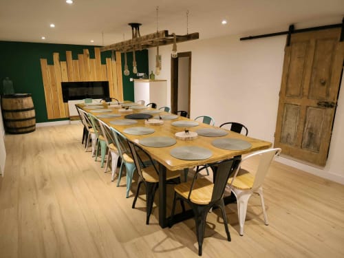 Salle à manger du Repaire Des Darous avec longue table en bois, chaises modernes et mur d'accent vert à Saulxures sur Moselle