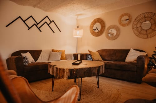 Salon chaleureux au Repaire Des Darous B&B à Saulxures sur Moselotte avec canapés marron, table en souche de bois et mur
