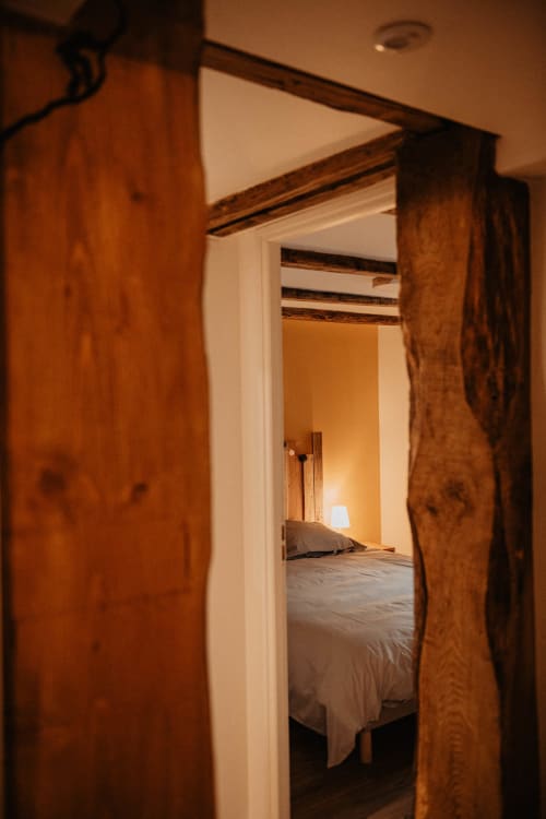 Des portes en bois s'ouvrent sur une chambre douillette au Repaire Des Darous B&B à Saulxures sur Moselotte