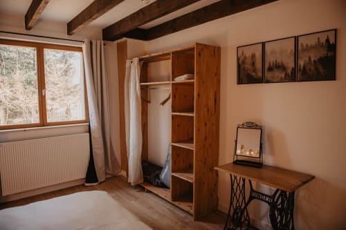 Chambre cosy au gîte Repaire Des Darous avec poutres apparentes, armoire, bureau et vue sur la forêt à Saulxures sur Moselotte