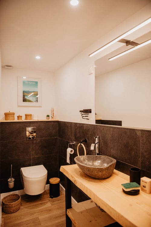 Salle de bain moderne avec lavabo en pierre et meuble-vasque en bois au Repaire Des Darous B&B à Saulxures sur Moselotte