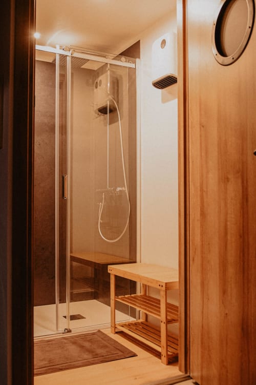 Douche vapeur moderne avec paroi vitrée et banc en bois à la Repaire Des Darous B&B à Saulxures sur Moselotte